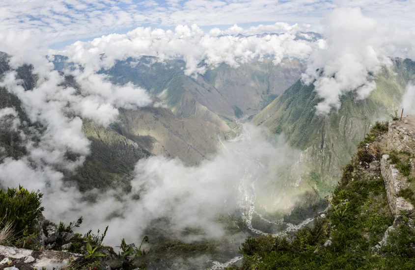 Panorama do Vale Sagrado envolto em nuvens, com montanhas e rios serpenteando pela paisagem.