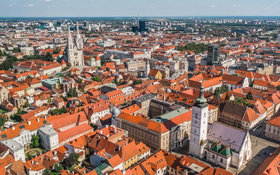 Vista panorâmica do centro de Zagreb, destacando os telhados vermelhos e a arquitetura histórica com a Catedral de Zagreb ao fundo