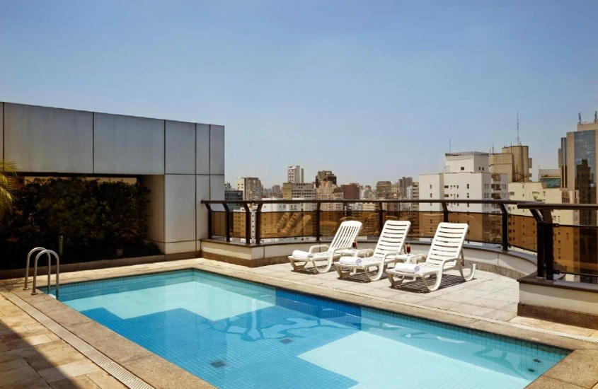 Cobertura de hotel com piscina, espreguiçadeiras e paisagem da natureza