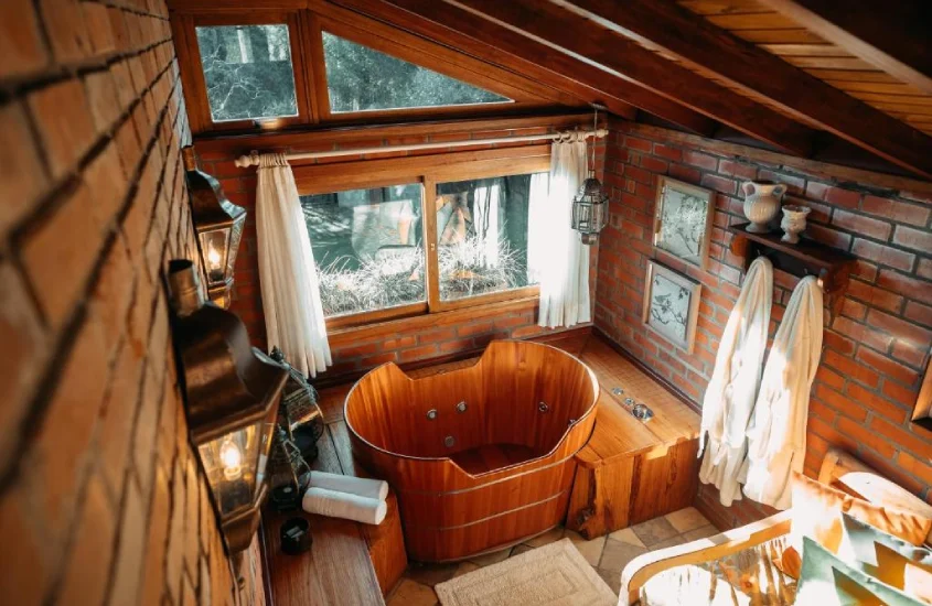 interior de cabana em um dos hotéis em vinícolas na serra gaúcha com janelas de madeira e toalhas ao redor