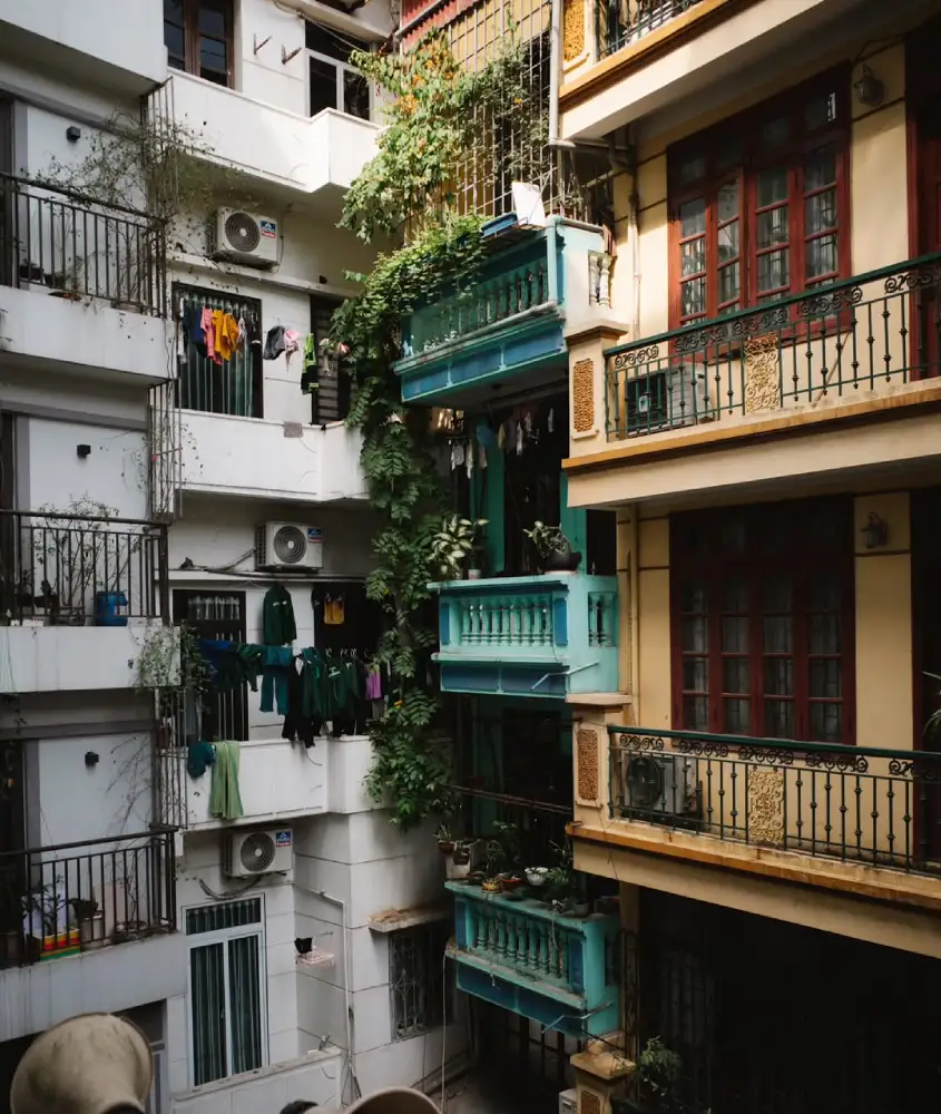 Prédios coloridos com varanda, plantas decorativas e roupas penduradas no varal.