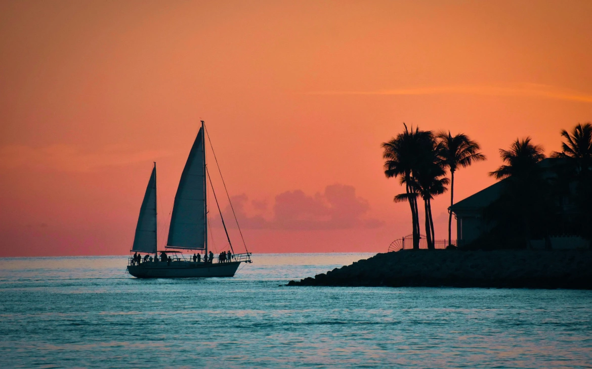 Durante o entardecer, paisagem do mar com barco e árvores ao redor