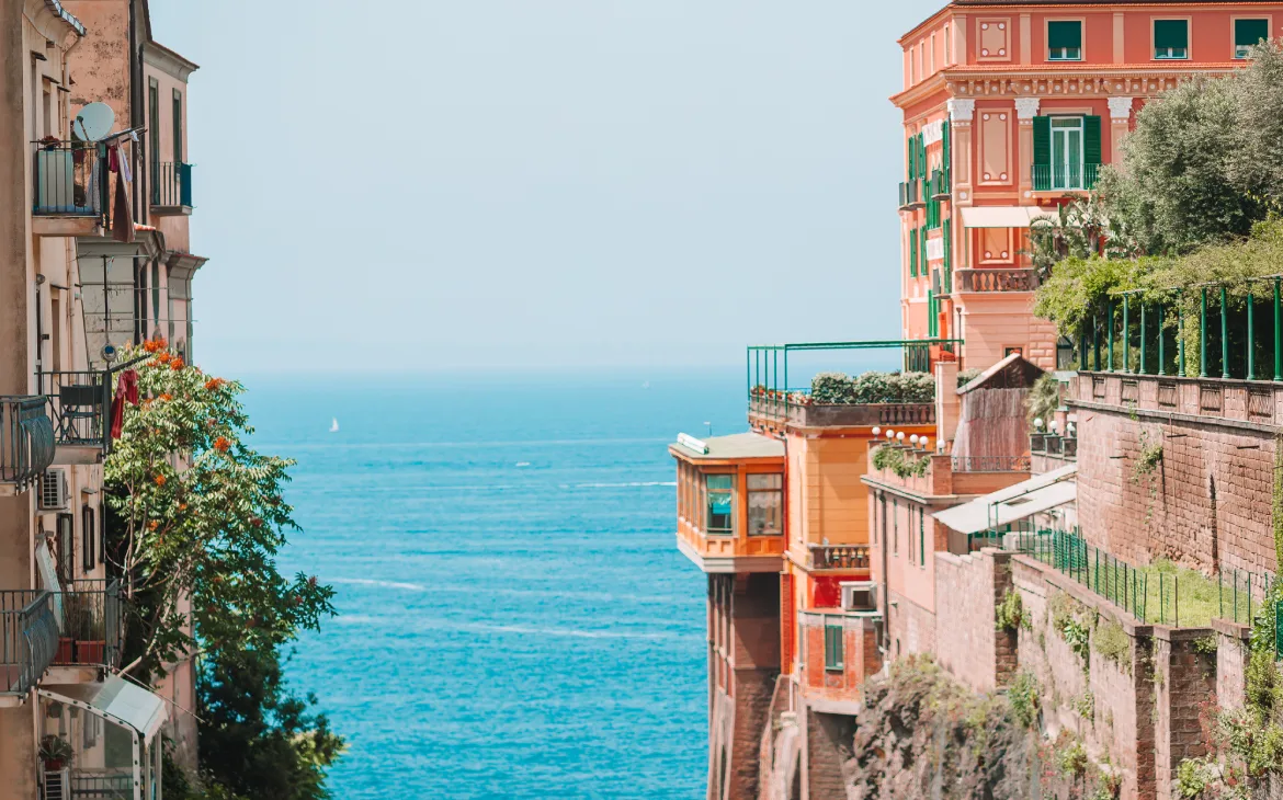 Em um dia de sol, paisagem de Sorrento com construções históricas e árvores ao redor