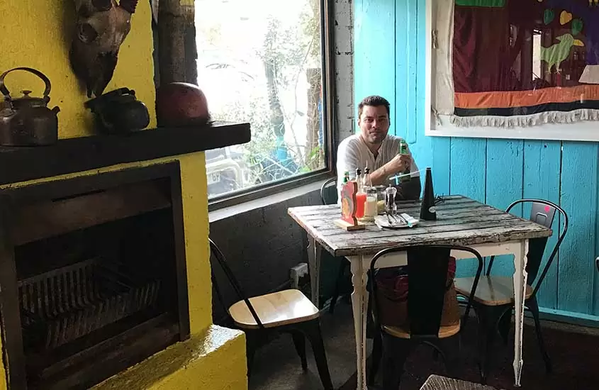 viajante sorri sentado em mesa de bar em Joanesburgo África do Sul