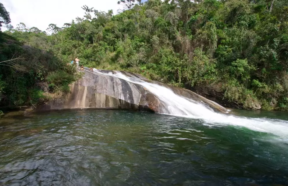 pessoas escorregam em cachoeira um dos principais atrativos entre muito o que fazer em Visconde de Mauá