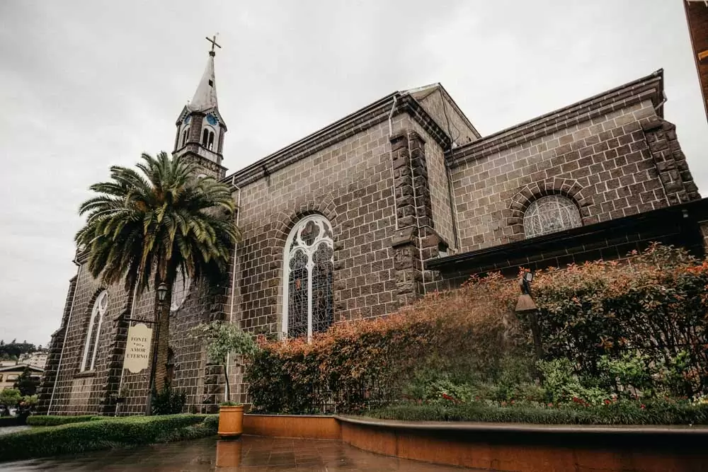 Igreja de tijolos cinzas sob o céu nublado, durante o dia, é um dos atrativos em Gramado, um dos melhores lugares para viajar a dois