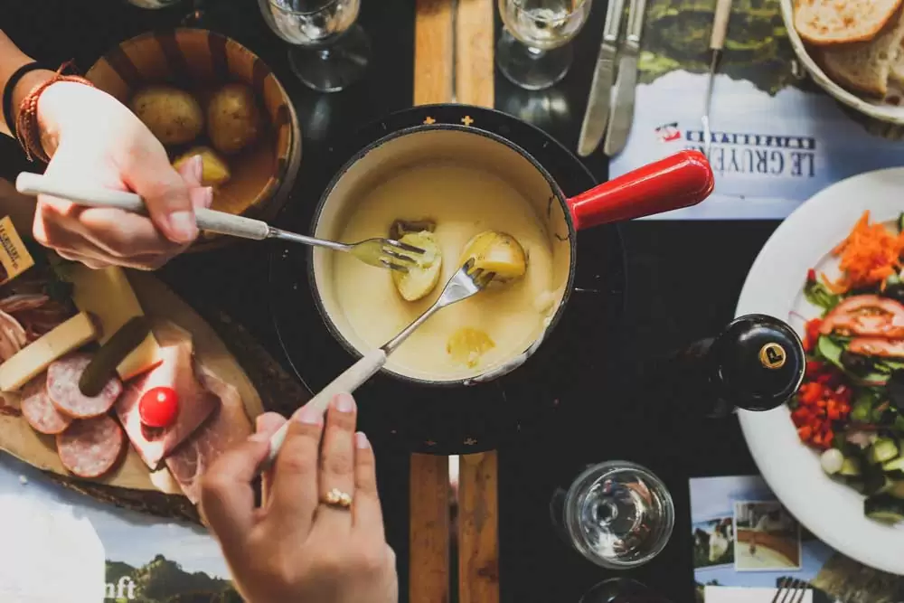 Casal divide fondue em restaurante em Visconde de Mauá, um dos lugares para viajar a dois