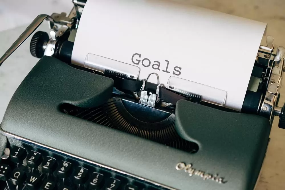 Papel onde há escrito "goals" (metas) saindo de máquina de escrever