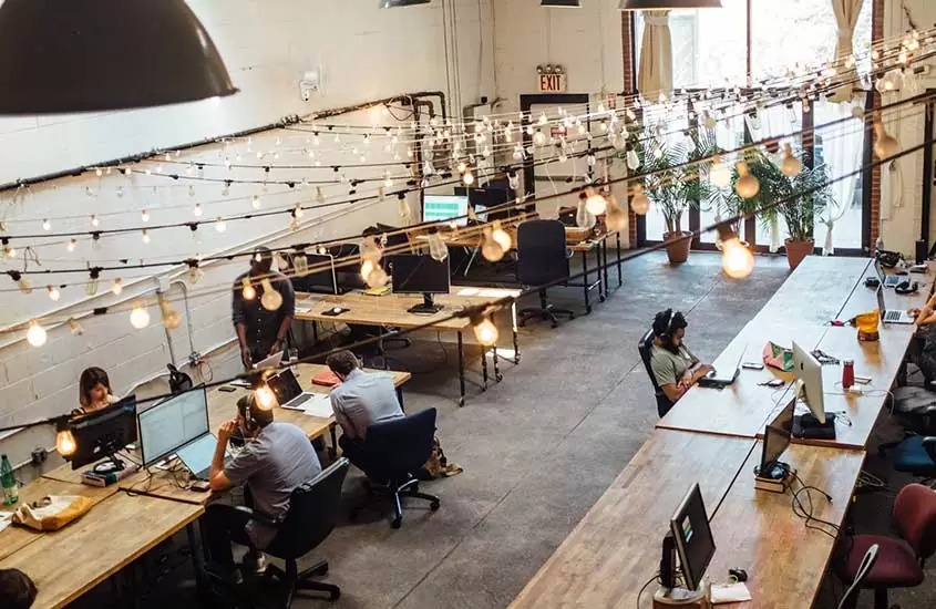 Pessoas trabalham durante o dia em um espaço coworking
