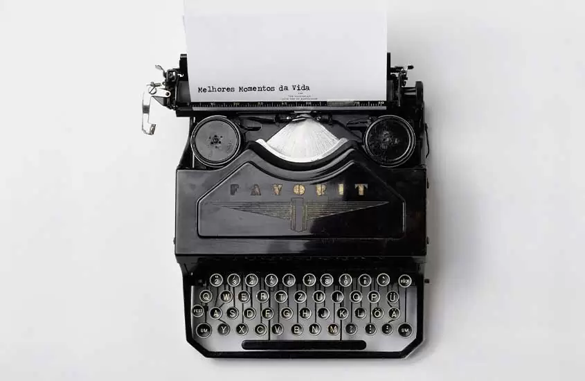 Papel com frase ''melhores momentos da vida'' saindo de máquina de escrever
