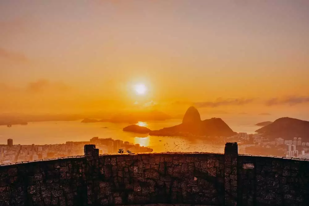 Silhueta de montanhas vistas de mirante no topo da cidade do Rio de Janeiro, durante o pôr do sol