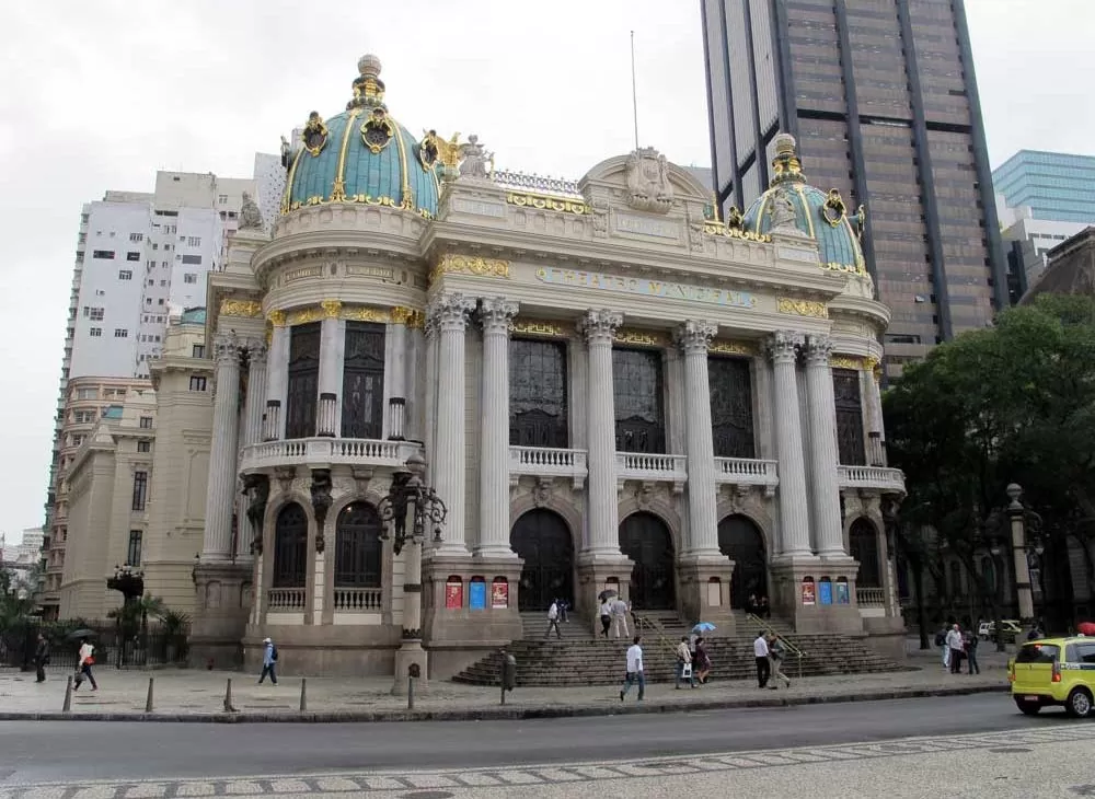 Construção centenária com fachada dourada, onde funciona o teatro municipal, uma opção entre os passeios do rj