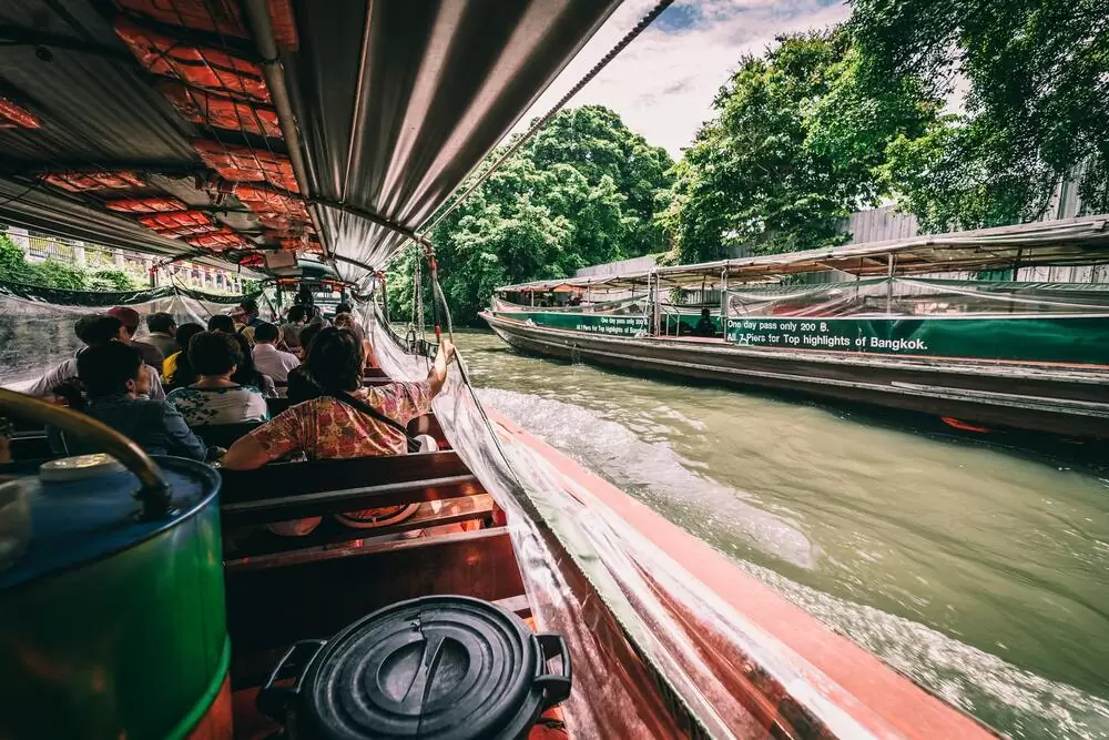 Pessoas passeiam de barco pelos canais de Bangkok, durante o dia