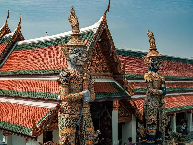 Estátuas gigantes coloridas em frente a Grande Palácio Real em Bangkok, capital da Tailândia, durante o dia
