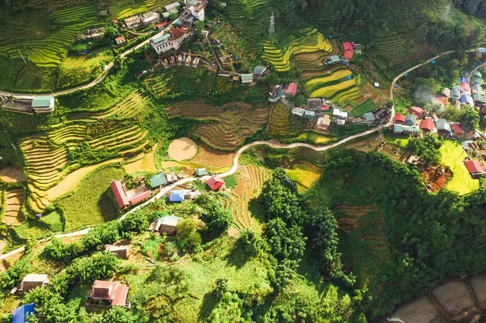 Vista aérea de casas coloridas, estrada e vegetação de cidade no Vietnã, um dos melhores lugares para viajar barato