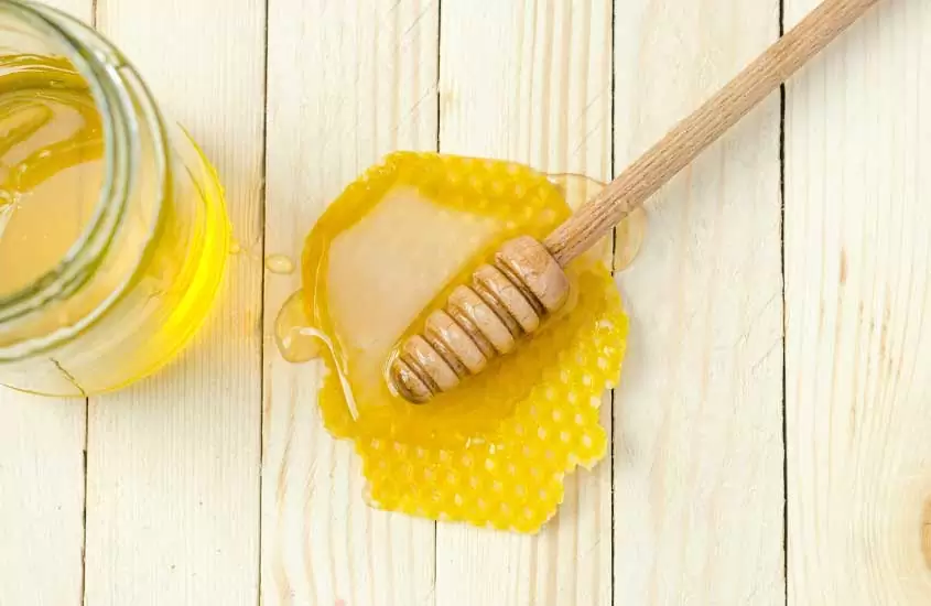 manuka honey, um mel famoso da nova zelandia, em cima de mesa de madeira