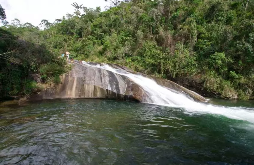 pessoas escorregam em cachoeira em Visconde de Mauá, um dos lugares para viajar no estado do rio de janeiro