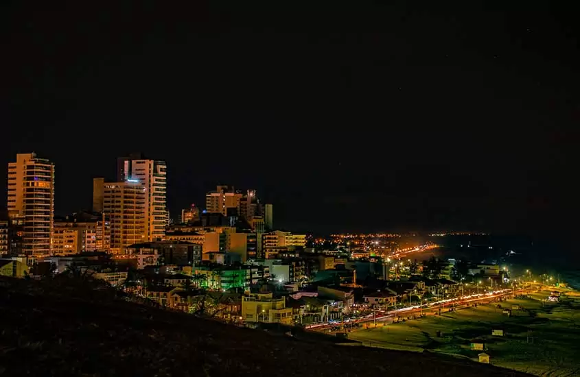 vista aérea de prédios em frente a praia, durante a noite, em torres