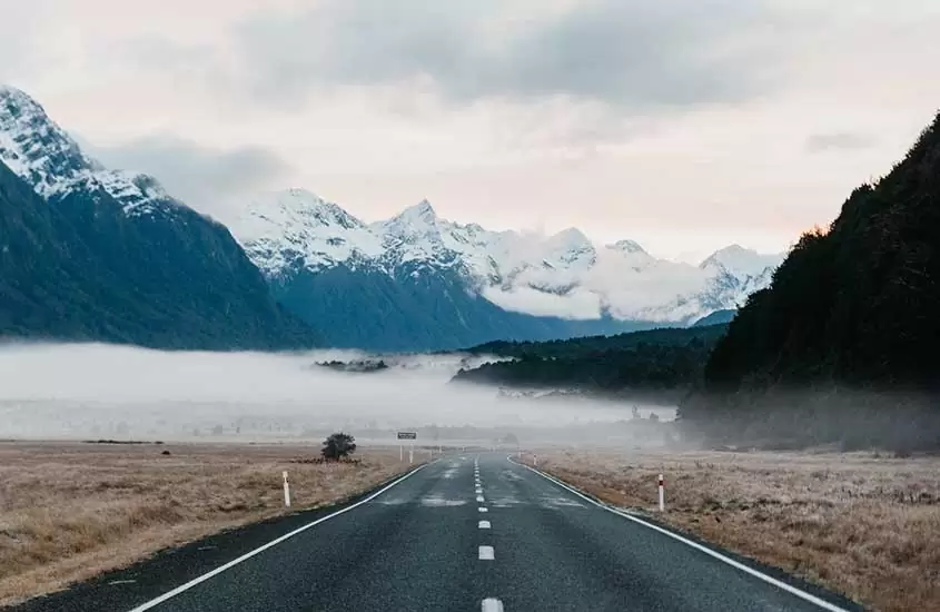estrada vazia e montanhas, durante o dia, na Nova Zelândia