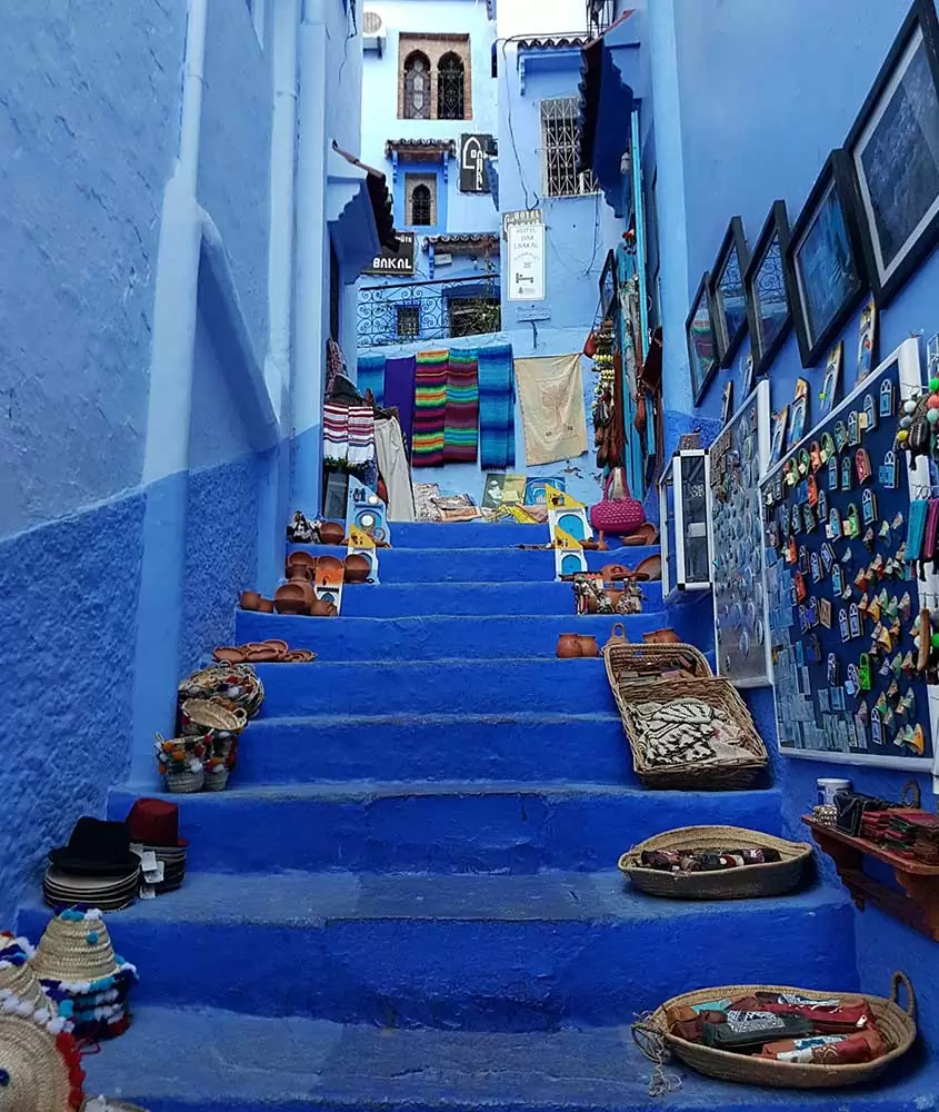 chapéus, quadros, cadeados em escada azul. Uma das curiosidades do Marrocos é que há uma cidade toda pintada de azul, conhecida como Chefchaouen