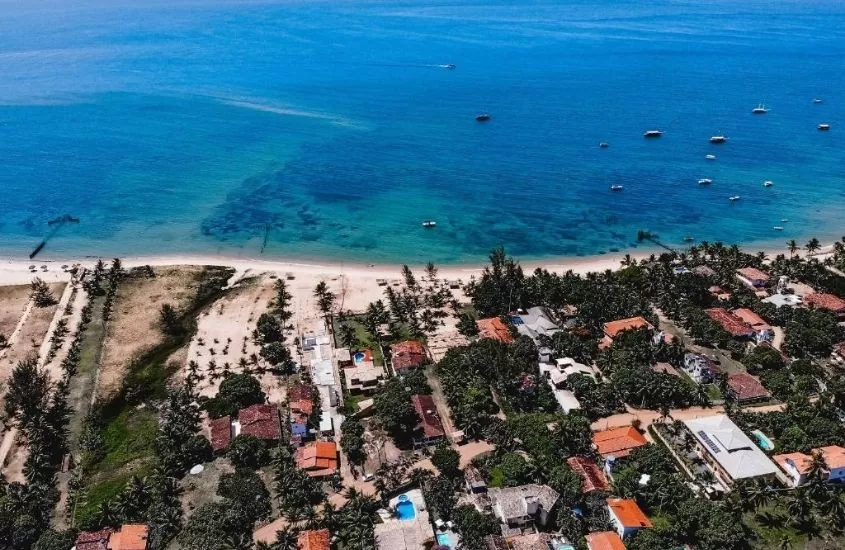 vista aérea de casas, areia e barcos no mar de Barra Grande, um dos lugares baratos para viajar na bahia