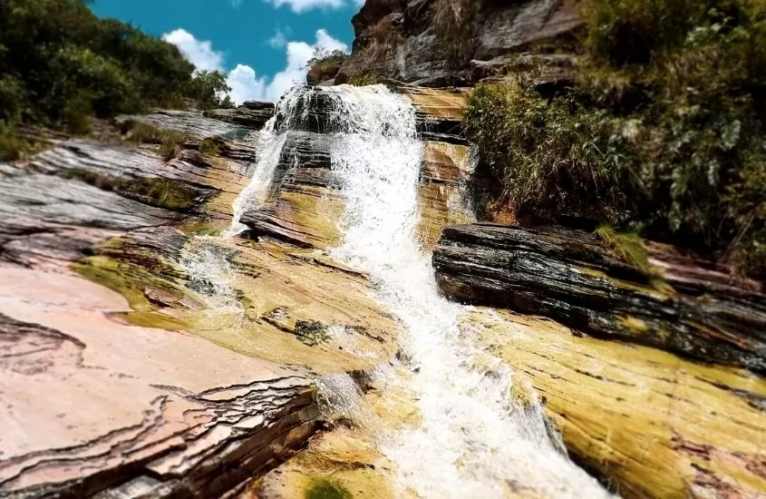 durante o dia, queda d'água de cachoeira caindo sobre as pedras em Ibitipoca, um dos lugares com cachoeiras em minas gerais