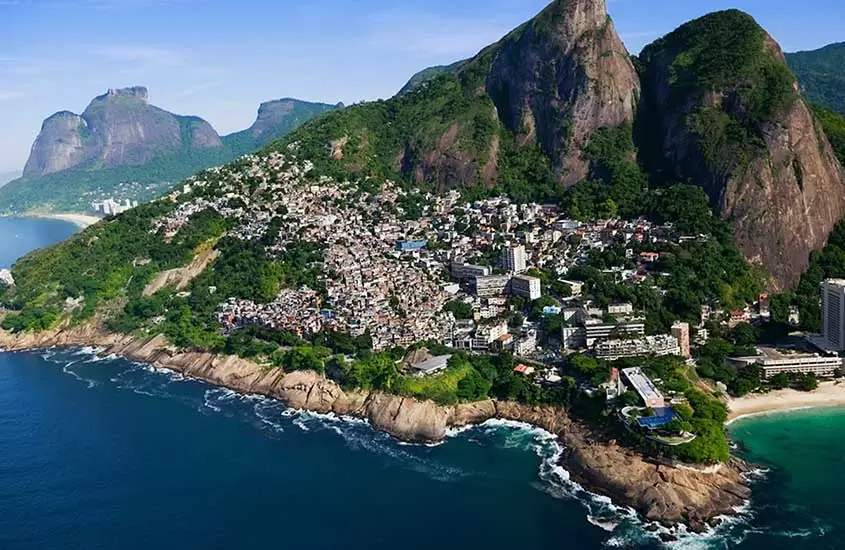 vista aérea de morro com casas em frente ao mar, durante o dia