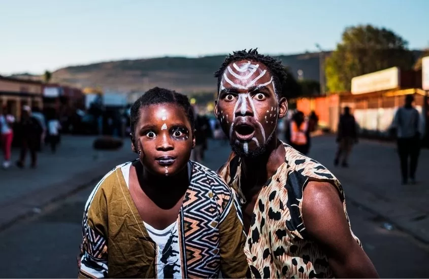 Menino e homem com pinturas no rosto e roupas culturais da Africa