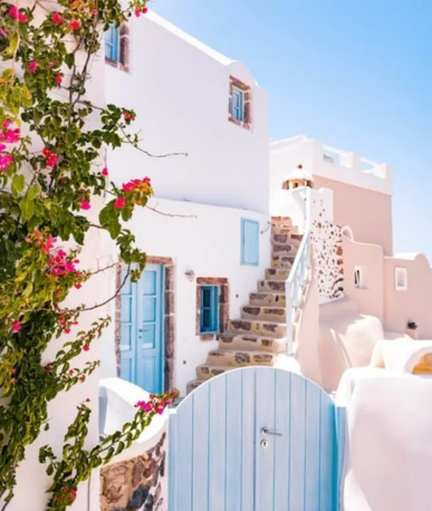 casa branca com portas e janelas azuis, sob céu azul, durante o dia em uma das ilhas gregas