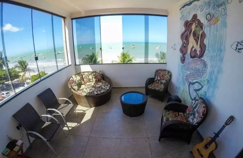 cadeiras e violão em sala com vista para o mar em Maraga Beach, um hostel em Maragogi