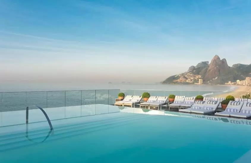 piscina de hotel fasano, um dos melhores hotéis de luxo no brasil, com borda infinita e vista para praia de ipanema em dia ensolarado