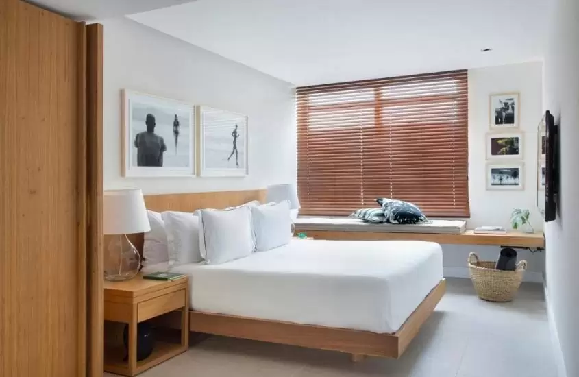 cama de casal em quarto com paredes brancas de janeiro hotel, um dos melhores hotéis de luxo no brasil
