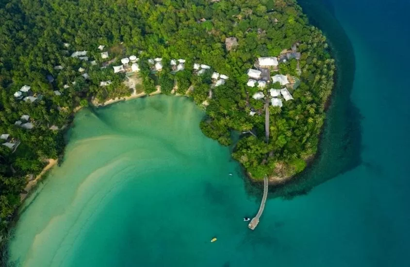 vista aérea de arvores e casas em ilha e barcos em mar na tailândia, durante o dia