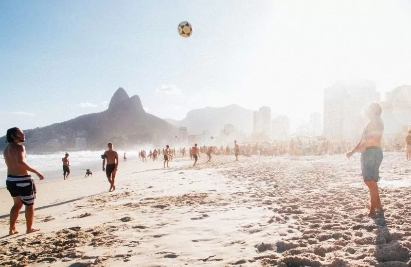 Jovens jogando altinha na praia do Arpoador, uma lugares mais bonitos do Rio de Janeiro