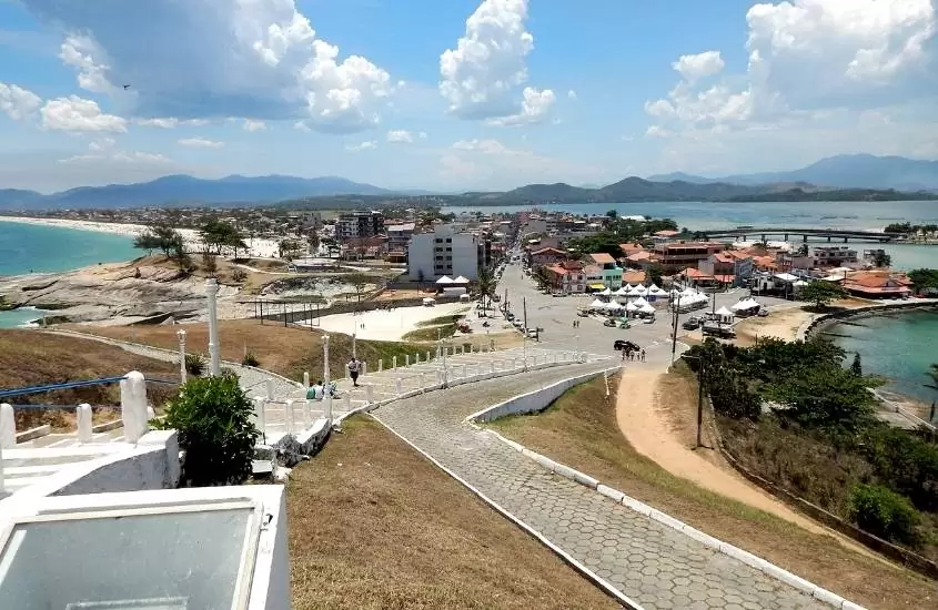 vista aérea de casas, ruas, mar e montanhas, durante o dia em saquarema