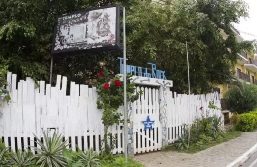 portão branco de museu com letreiro escrito ''templo do rock'' em saquarema