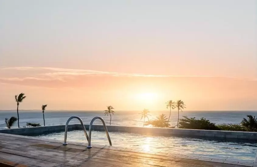 piscina com vista para o mar, durante o entardecer, em rox hotel, um dos melhores hotéis em jericoacoara