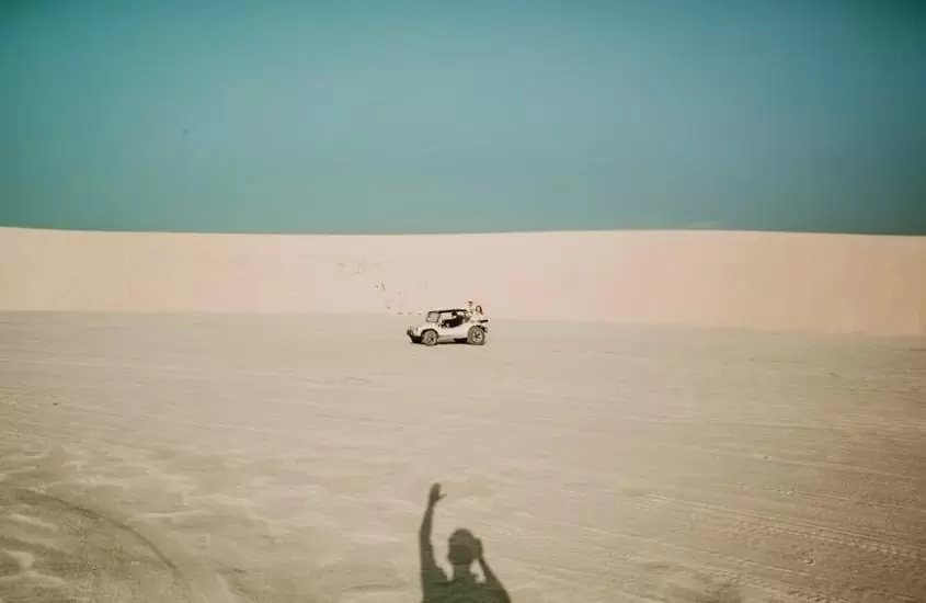 pessoas andam de buggy em dunas, durante o dia, em passeio litoral leste, um dos melhores passeios em jericoacoara