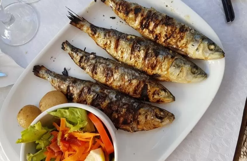 peixes e salada em cima de prato branco em mesa de um dos melhores restaurantes em jericoacoara