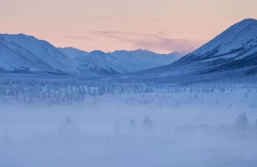 montanhas cobertas de neve, durante o entardecer em oymyakon, a cidade mais fria do mundo