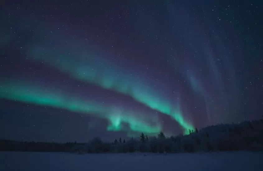 aurora boreal ilumina céu de yellowknife, única cidade nos territórios do noroeste do canadá
