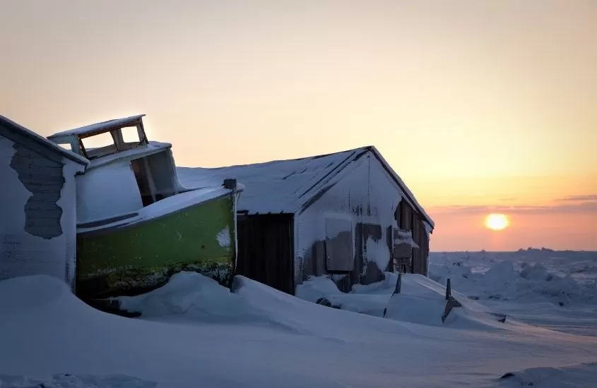 barco e casa cobertos de neve, durante entardecer em barrow, cidade nos estados unidos que é considerada uma das mais frias do mundo