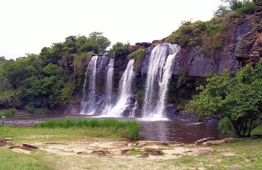 cachoeira cercada de árvores, durante o dia em carrancas, um lugar para fazer ecoturismo em minas gerais