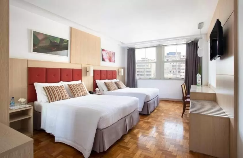camas de casal em quarto com vista para a cidade em normandy hotel, um dos melhores hotéis e pousadas em belo horizonte