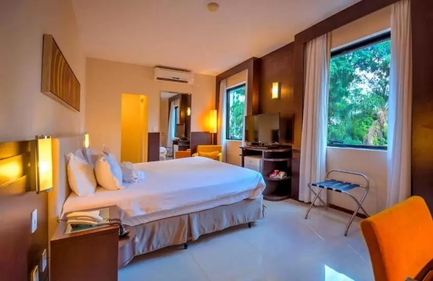 cama de casal em quarto com janela aberta com vista para arvores em royal boutique savassi hotel, um dos melhores hotéis em belo horizonte