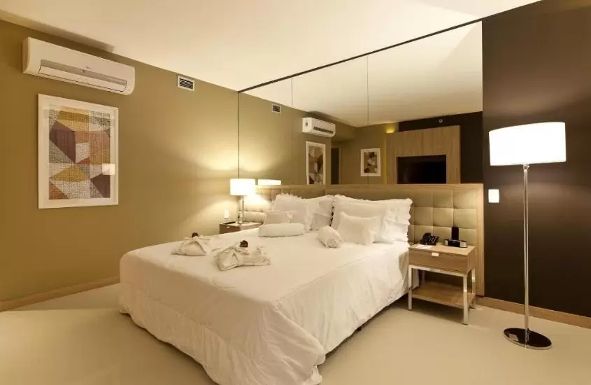 cama de casal e abajur em quarto de esuites savassi toscanini, uma boa opção para se hospedar entre os hotéis e pousadas em belo horizonte