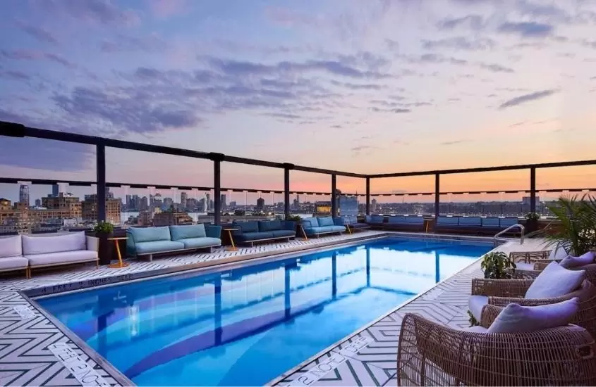 sofás e piscina, durante o entardecer em terraço de gansevoort meatpacking , um dos hotéis mais caros do mundo, localizado em nova york