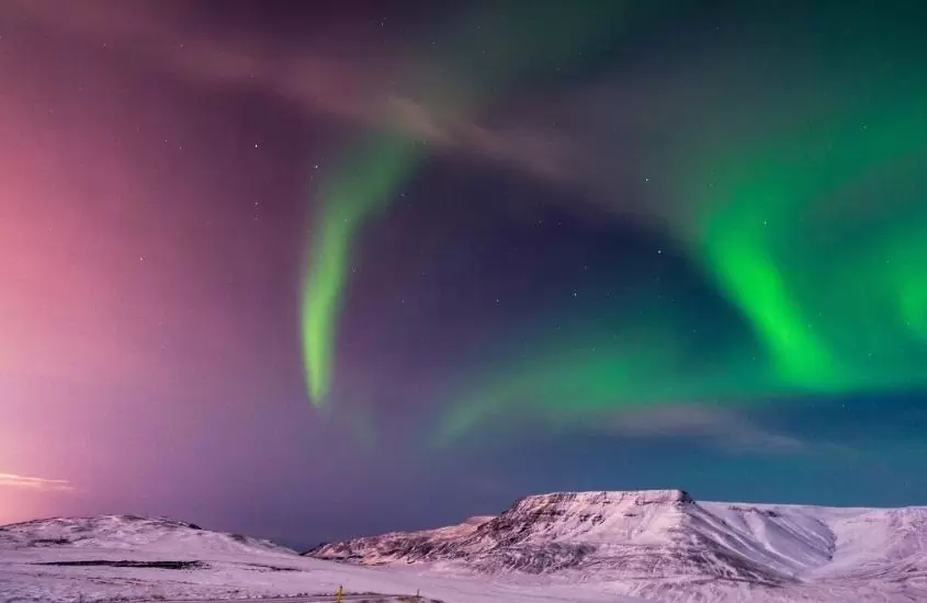 aurora boreal ilumina o céu de reikjavìk, capital da islândia que é um dos lugares caros para viajar