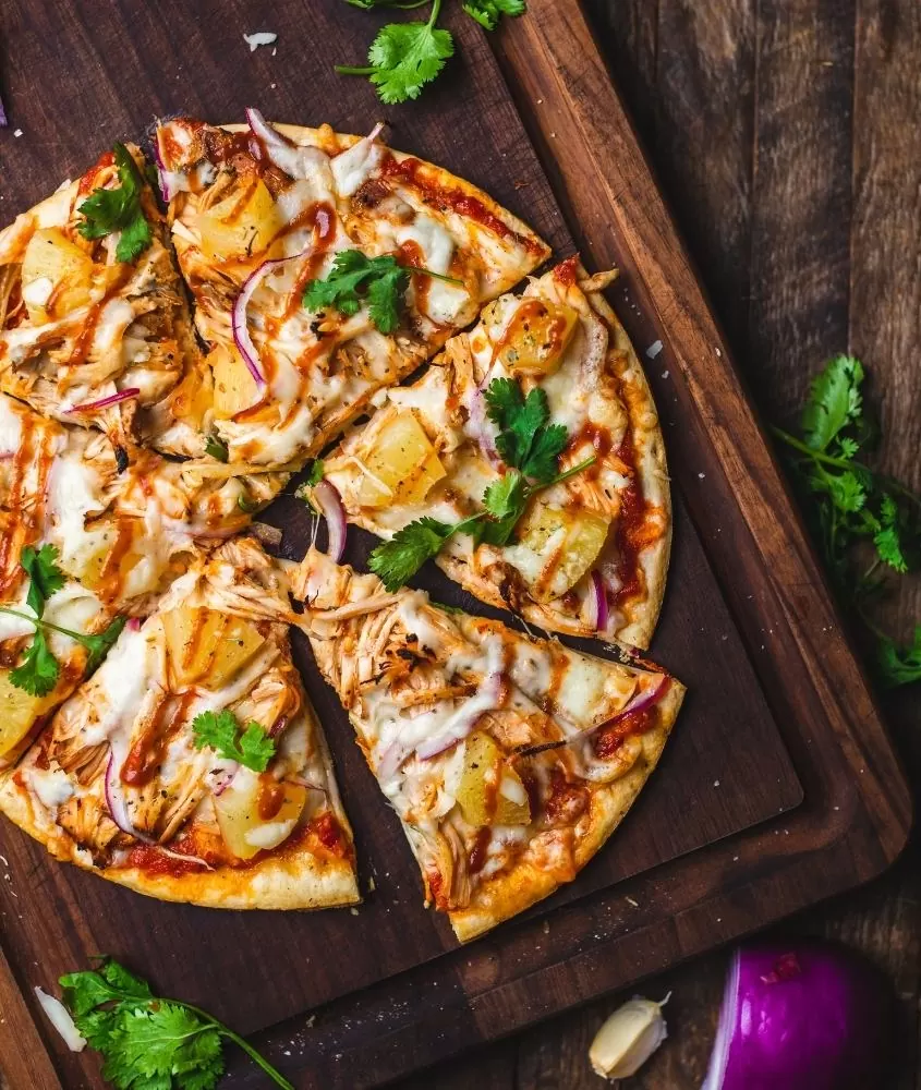 pizza de marguerita fatiada em cima de bandeja de madeira
