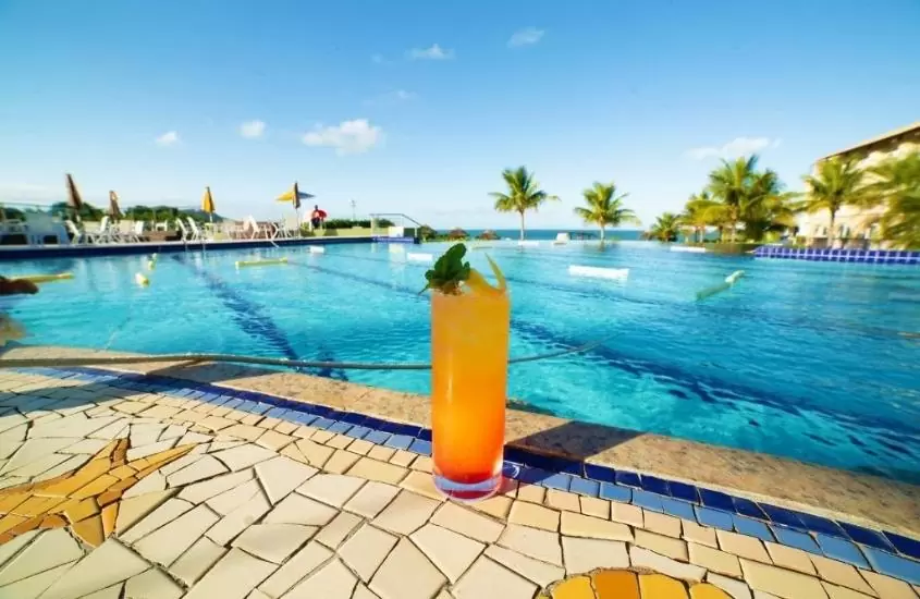 drink na beira de piscina com vista para o mar, durante dia ensolarado em florianópolis